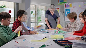 Multiethnic teen students having origami class at school