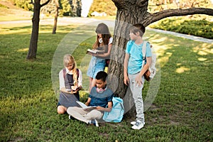 Multiethnic teenagers studying in park