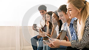 Multiethnic Teenagers Using Smartphones Together During a Casual Indoor Gathering