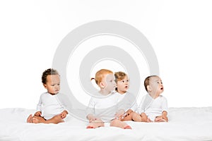 adorable multiethnic toddler boys and girls looking away photo