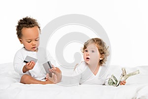 multiethnic toddlers holding money and credit cards