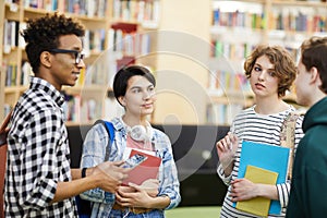 Multiethnic university students talking in library