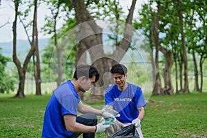 Multiethnic volunteers donate their time holding black garbage bags to collect plastic waste for recycling to reduce