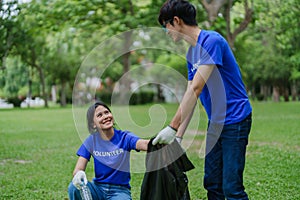 Multiethnic volunteers donate their time holding black garbage bags to collect plastic waste for recycling to reduce