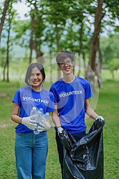 Multiethnic volunteers donate their time holding black garbage bags to collect plastic waste for recycling to reduce