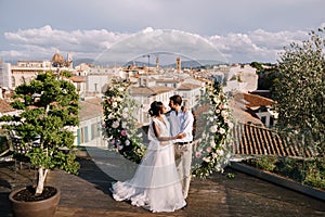 Multiethnic wedding couple. Destination fine-art wedding in Florence, Italy. A wedding ceremony on the roof of the