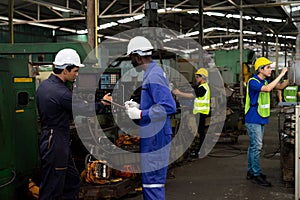 Multiethnic worker, supervisor wearing mask in manufacturing factory on business day