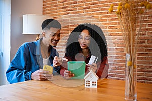 Multiethnic young couple shopping online with credit card and smartphone inside