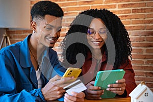 Multiethnic young couple shopping online with credit card and smartphone inside