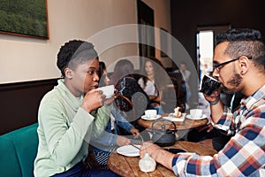 Multiethnic young couple talking over drinks in a cafe