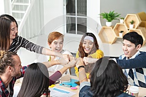 Multiethnic young team stack hands together as trusted unity and teamwork in modern office. photo