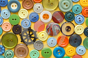 Multifarious buttons for clothes on yellow