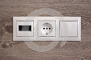 Multifunction outlet with network line-connection internet plug, Electrical socket, Electric light switch on Wood wall background