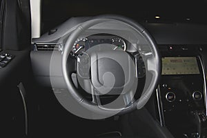 Multifunction steering wheel in leather car interior at night