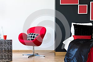 Multifunctional bedroom with red chair