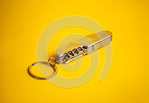 multifunctional metal knife on a yellow background
