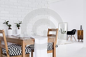 Multifunctional white interior with decorative brick wall