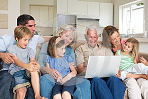 Multigeneration family using laptop in living room