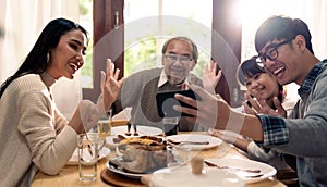 Multigenerational asian family selfie and eating lunch together