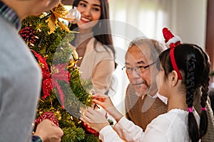 Multigenerational Family decorating a Christmas tree for season greeting