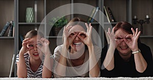 Multigenerational family having fun laughing making eyewear shape with fingers