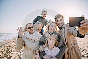 multigenerational family taking selfie on smartphone photo