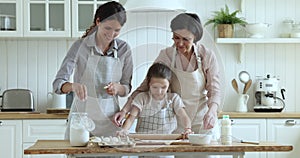 Multigenerational family teach little girl to prepare dough for pastries