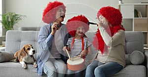 Multigenerational women family blowing party horns, play drums