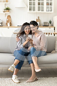 Multigenerational women, mom and daughter doing online shopping using cellphone