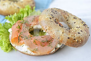 Multigrain bagel with cream cheese, salmon slices, dill and saladpices, slow motion.