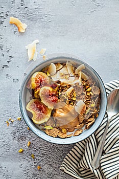 Multigrain breakfast cereals with fig, coconut chips, peanut butter and pistachio. Vegan breakfast concept