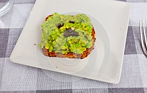 Multigrain toast with guacamole and pumpkin seeds on plate