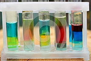 Multilayer systems of colored liquid insoluble substances in test tubes.
