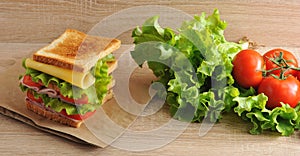 Multilayered sandwich with cheese, ham, tomatoes and lettuce