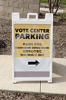 A multilingual voting center parking sign with arrow