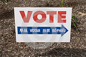 A multilingual voting sign with arrow in red white and blue