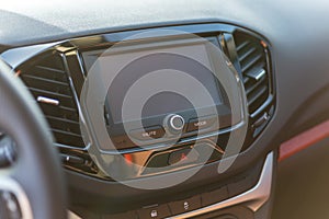 A multimedia panel with a screen and control buttons in a modern car.