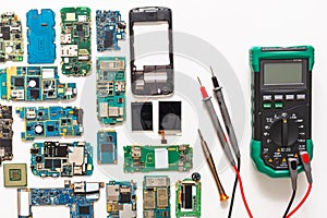 Multimeter and broken mobile electronics at repair shop