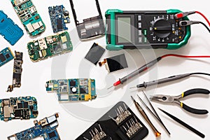 Multimeter and broken mobile electronics at repair shop