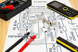 Multimeter probes examining a computer circuit board and circuit