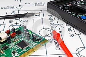 Multimeter probes examining a computer circuit board