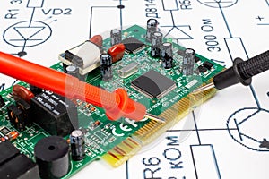 Multimeter probes examining a computer circuit board