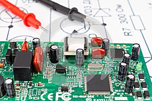 Multimeter probes examining a computer circuit board
