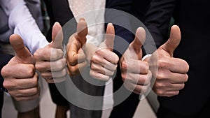 Multinational businesspeople standing in row showing thumbs up gesture closeup