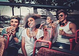 Multinational friends riding on a sightseeing bus photo