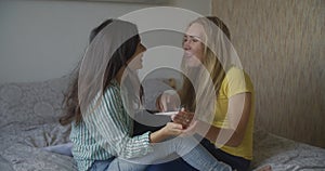 Multinational lesbian couple. Two young women lesbian girls show each other a pregnancy test and are very happy that