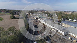 Multiple antique restored steam locomotives moving around in a train yard blowing black smoke and steam