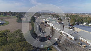 Multiple antique restored steam locomotives moving around in a train yard blowing black smoke and steam