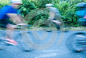 Multiple bicyclists blurred to show motion