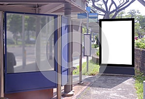 Multiple blank vertical advertising poster banner mockups at bus stop shelter by main road, at residential neighbourhood; out-of-